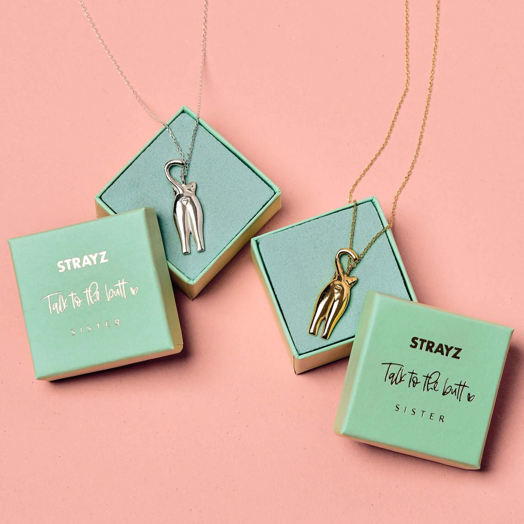 Katzen-Kette aus 925 Sterling Silber in den Farben Silber und vergoldet. Die Ketten mit Katzenmotiv kommen in schönen mintgrünen Geschenkboxen. Auf diesen Boxen sind die Logos der Female Founded Start-ups STRAYZ und Sister zu sehen mit dem Statement: Talk to the Butt, weil die Kette für Empowerment steht.