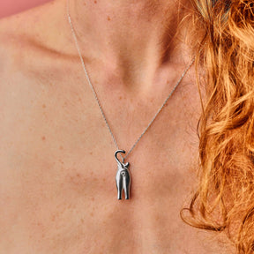 Die Katzen-Kette aus 925 Sterling Silber am Hals eines Models getragen. Die Kette mit Katzenmotiv-Anhänger zeigt eine Katze von Hinten. Das Poloch ist ein Herz. Tolle Geschenkidee für Katzenfans.