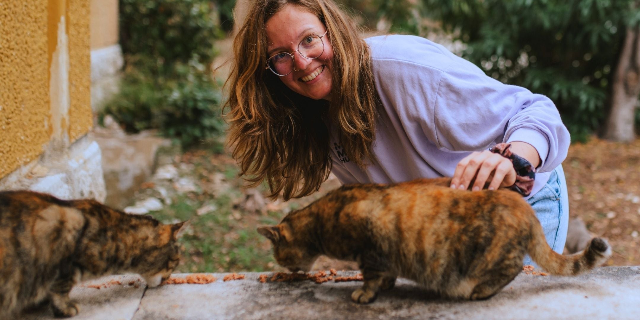 Co-Founder von STRAYZ Madeline streichelt eine Straßenkatze in Kroatien und hilft beim Füttern eines Tierschutzvereins in Split. 