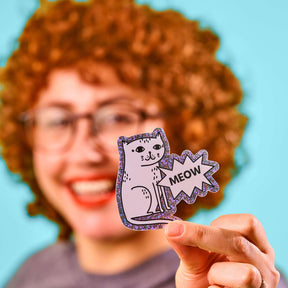 STRAYZ Katzen Glitzersticker "Meow" wird von einer Frau in die Kamera gehalten.