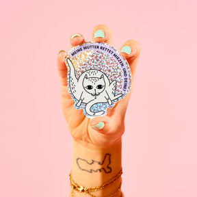 STRAYZ Katzen Glitzersticker "Miez-Held*in" von einer Hand gehalten.